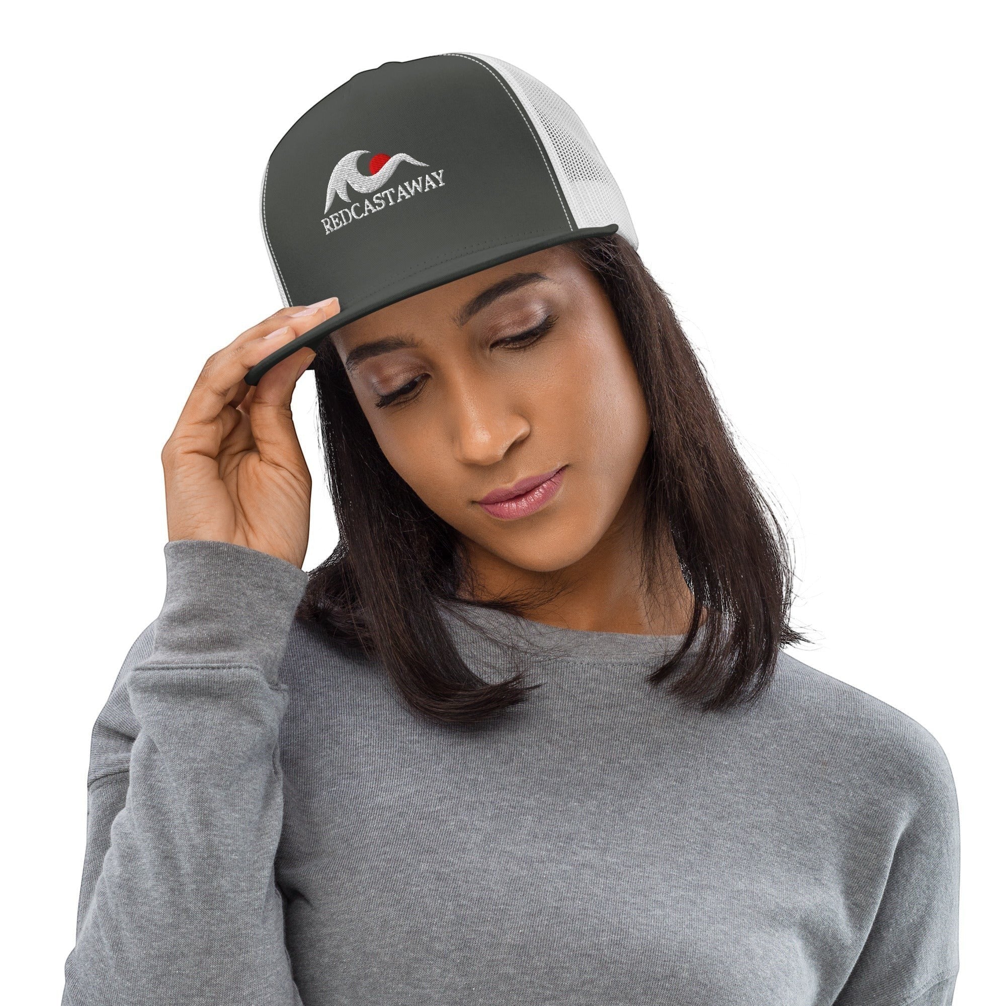 Redcastaway trucker cap in dark grey with white mesh back and embroidered logo. Features a flat bill and snapback closure.