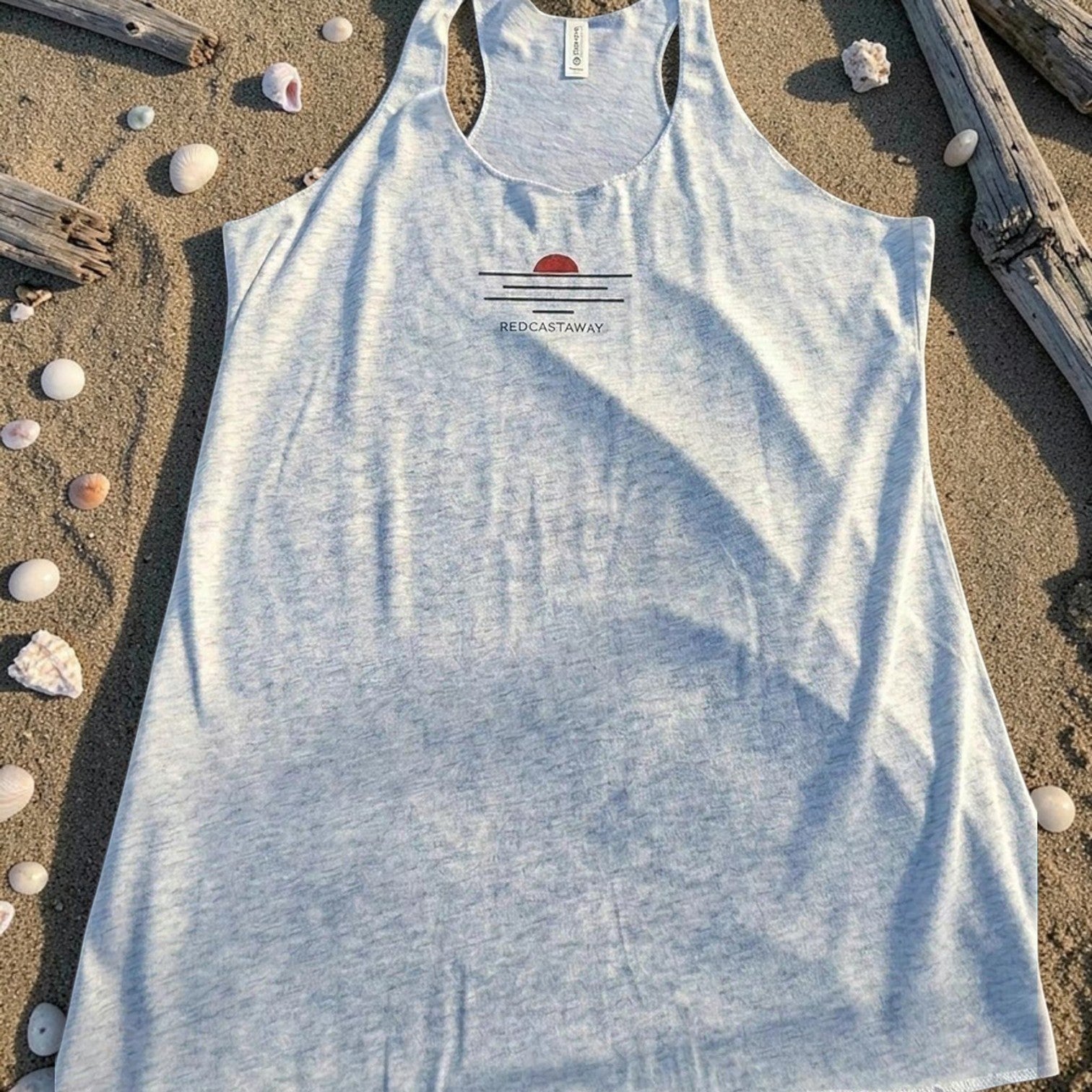 Redcastaway™ women's light blue heathered racerback tank top with a sunset graphic and raw edge seams. Made from a polyester, cotton, and rayon blend.